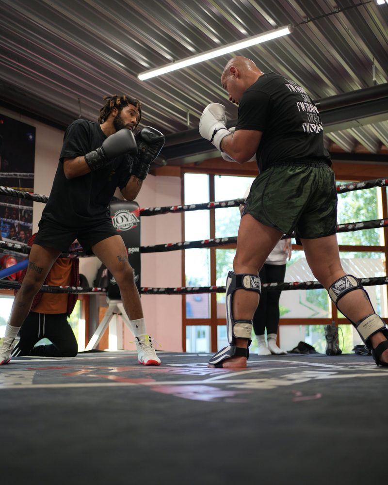 Twee sporters sparren in de ring, de ene houdt zijn voorste hand klaar om te stoten